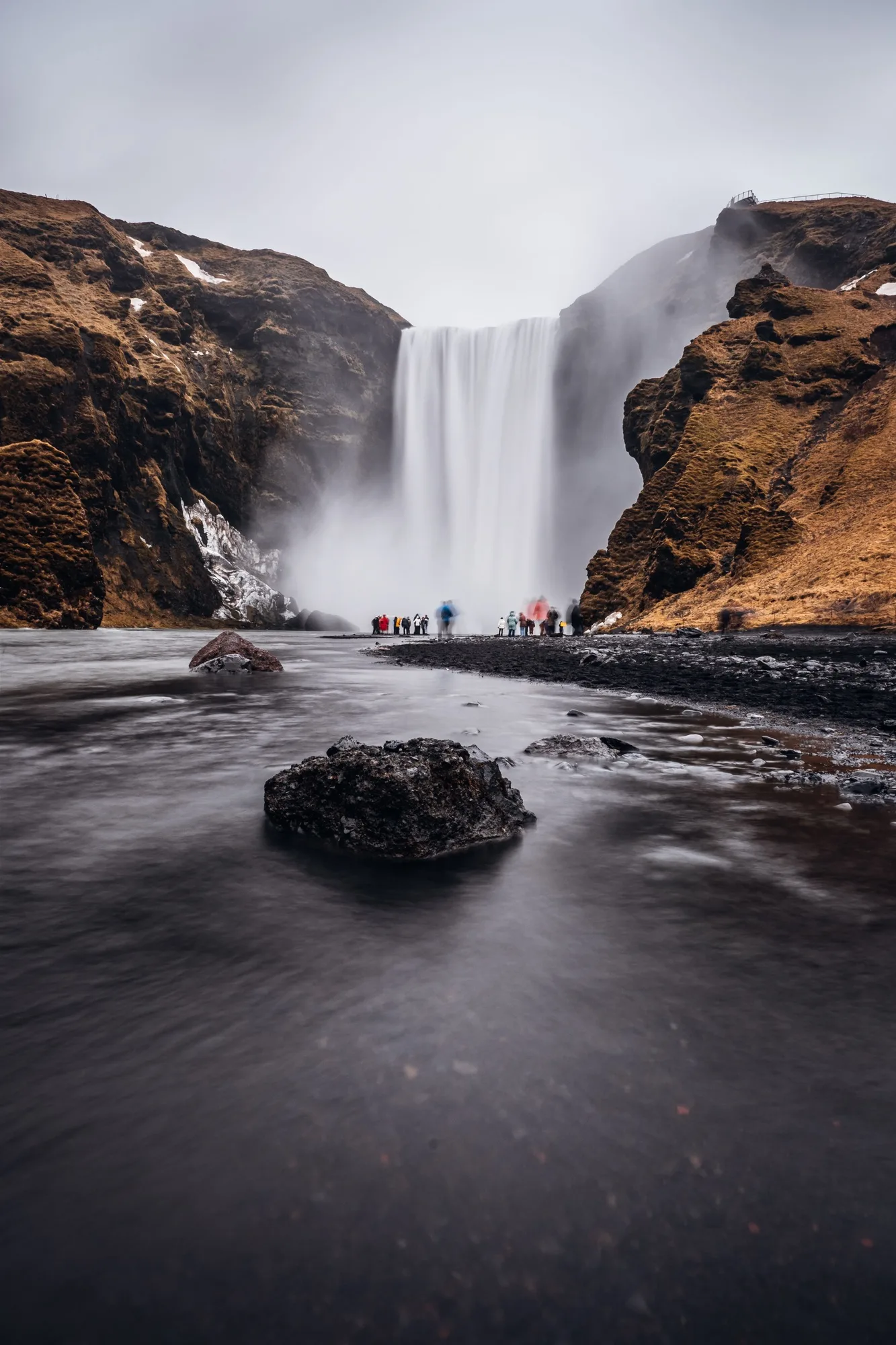 cascading waterfall amidst a winter wonderland of snow and grass, in Reykjavik, Iceland